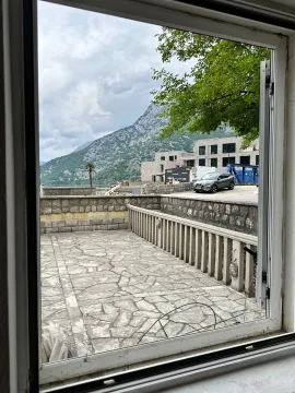 View through the window of the terrace, surrounding buildings, and mountains. - image 10