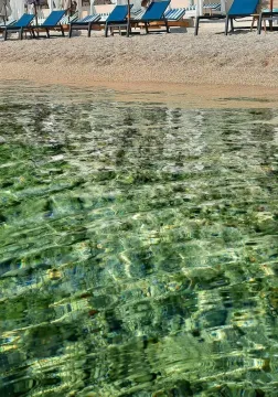 Pogled na čistu morsku vodu i plažu sa ležaljkama. - image 4