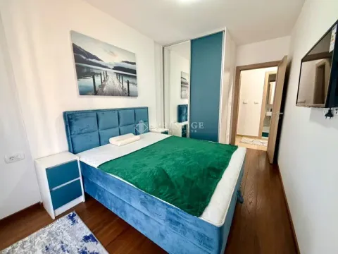 Furnished bedroom with a double bed, wardrobe, and TV. - image 9