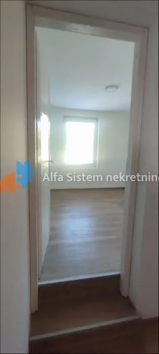 View through the doorway into an empty room with a window.