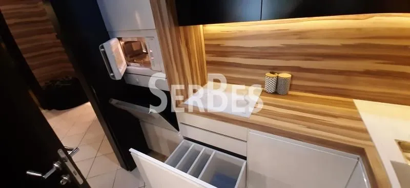 Moderna kuhinja sa drvenim radnim površinama i ugradnim elementima.