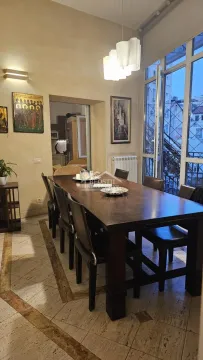 Prostrana trpezarija sa velikim drvenim stolom i stolicama pored balkonskih vrata. - image 7