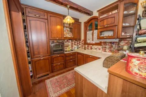 Traditional kitchen with wooden cabinetry and a built-in oven. - image 37