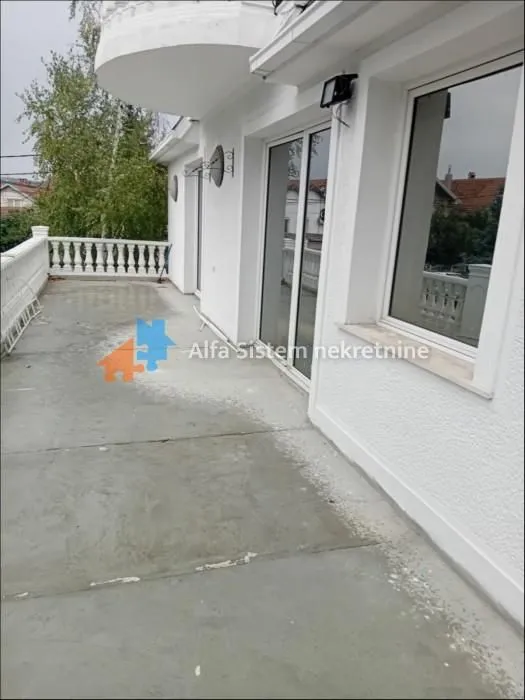 Large spacious terrace with a white railing and surrounding view.