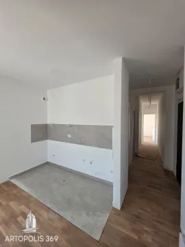 View of a part of an apartment under construction with ceramic tiles on the floor and walls and a hallway in the background. - image 9