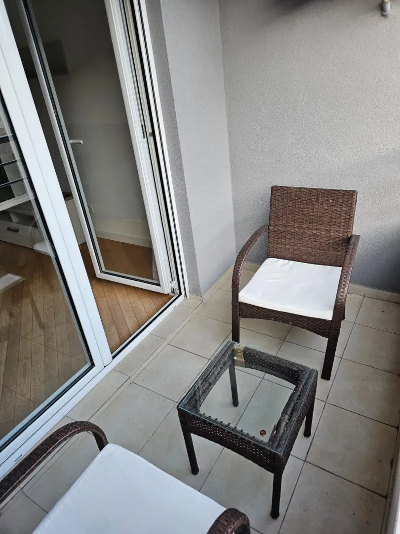 Manji natkriveni balkon sa garniturom za sjedenje i izlazom u unutrašnji prostor.