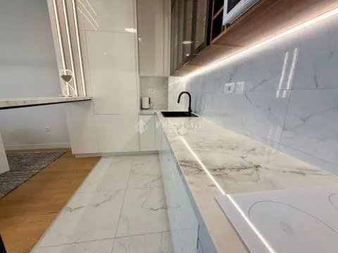 Modern kitchen with a marble countertop and built-in lighting. - image 8