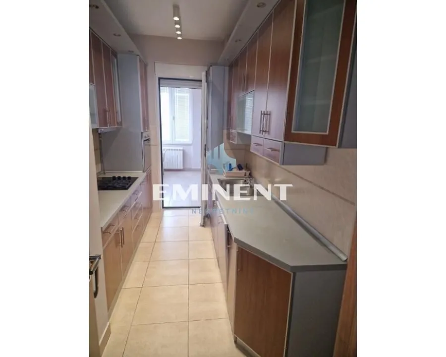 Narrow kitchen with wooden cabinetry and appliances.