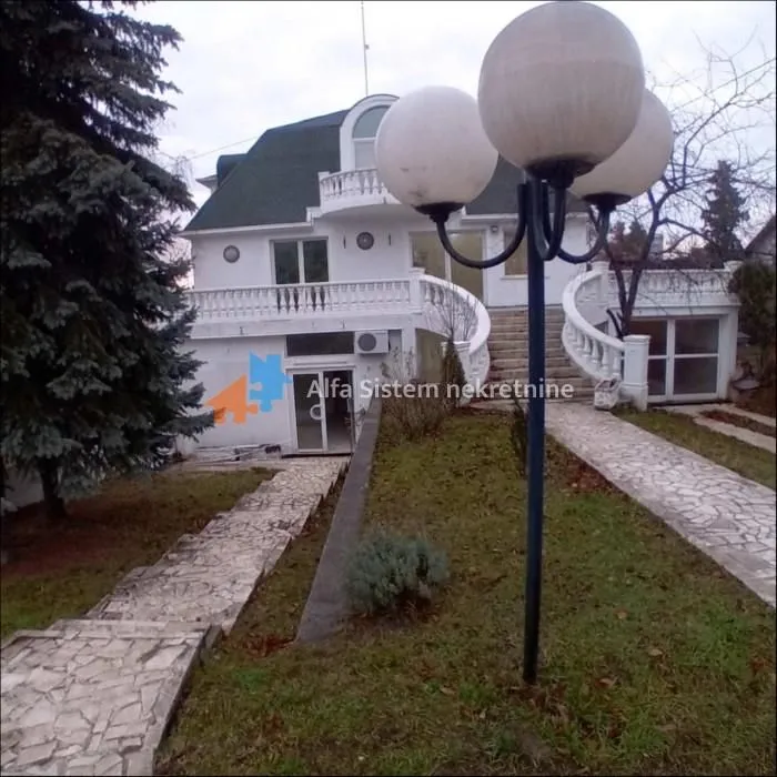 View of the courtyard and exterior of the house with paved pathways and lighting.