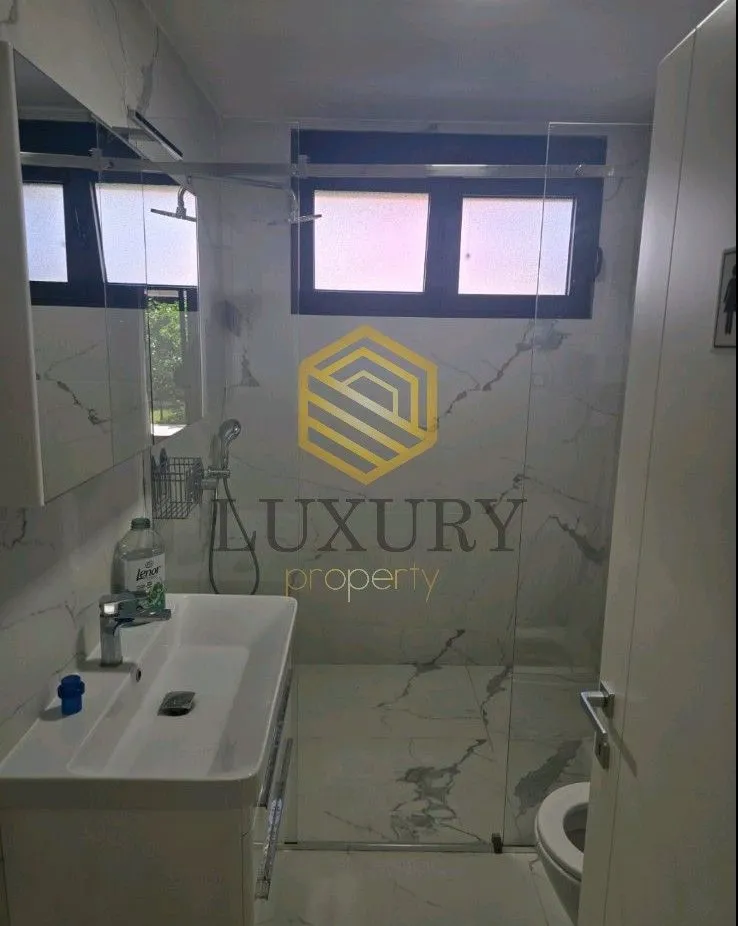 Modern bathroom equipped with a washbasin and a walk-in shower.
