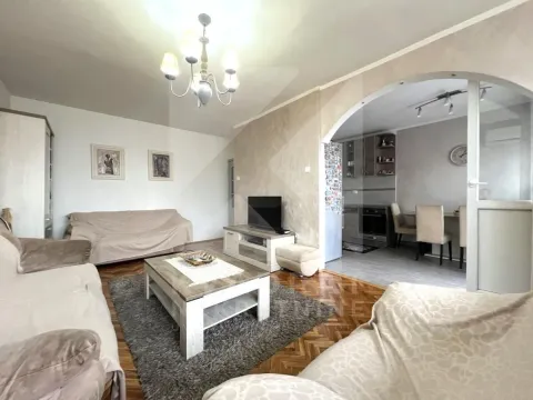 Living room with a sofa, coffee table, and TV, with a view of the dining area and kitchen. - image 3