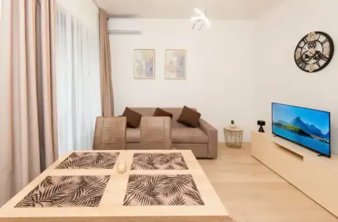 Living room with dining table, sofa, and television. - image 9