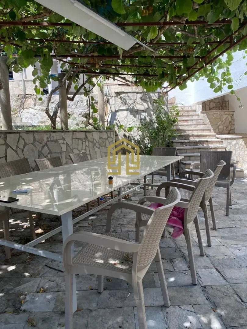 Covered terrace with a dining table and chairs in the courtyard.