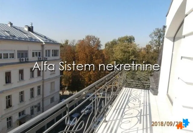 Spacious balcony with a view of surrounding buildings and trees.