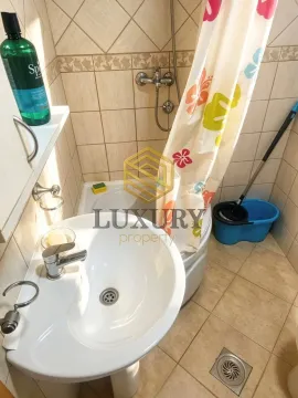 Smaller bathroom with a washbasin, shower cabin, and ceramic tiles. - image 2