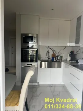 Moderna bela kuhinja sa ugrađenom rernom i mikrotalasnom. - image 3
