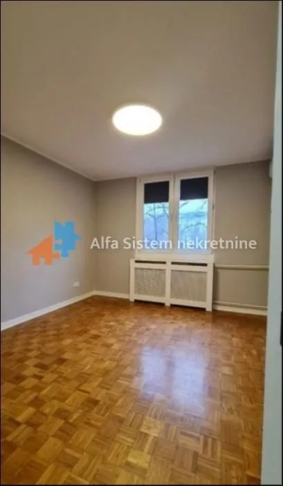 Empty room with parquet flooring and a window.