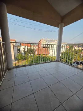 Prostrana pokrivena terasa sa keramičkim pločicama i pogledom na okolinu. - image 9