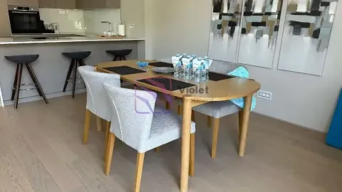 Trpezarija sa drvenim stolom i modernim stolicama povezana sa kuhinjom. - image 10