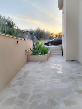 Tiled courtyard in front of the house with stairs and a car. - image 6
