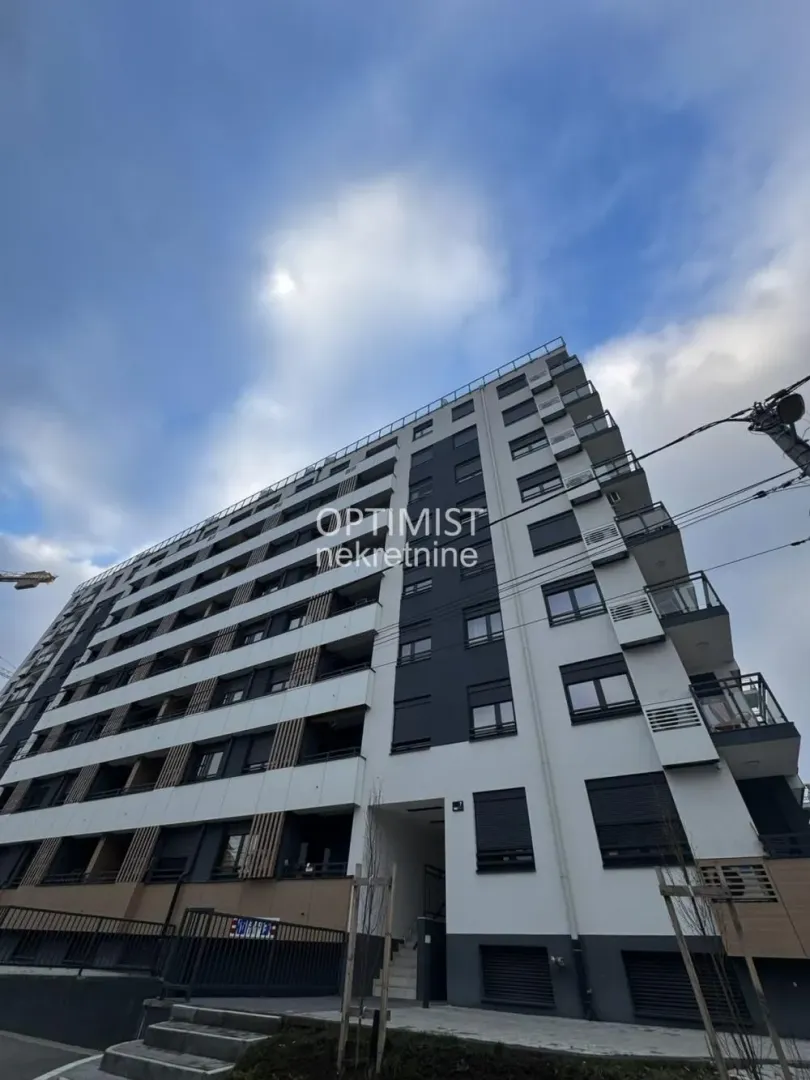 Pogled na spoljašnjost moderne višespratne stambene zgrade sa balkonima.