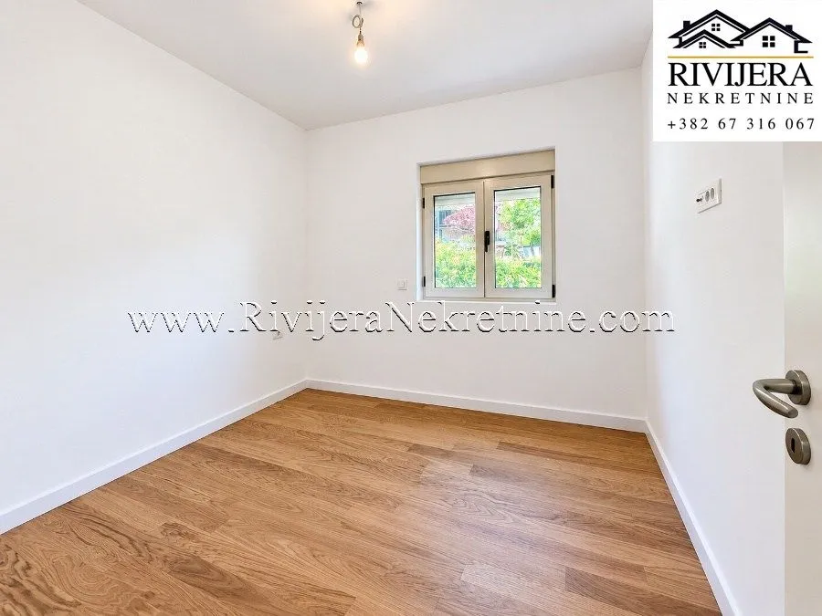 Empty room with white walls and a wooden floor.