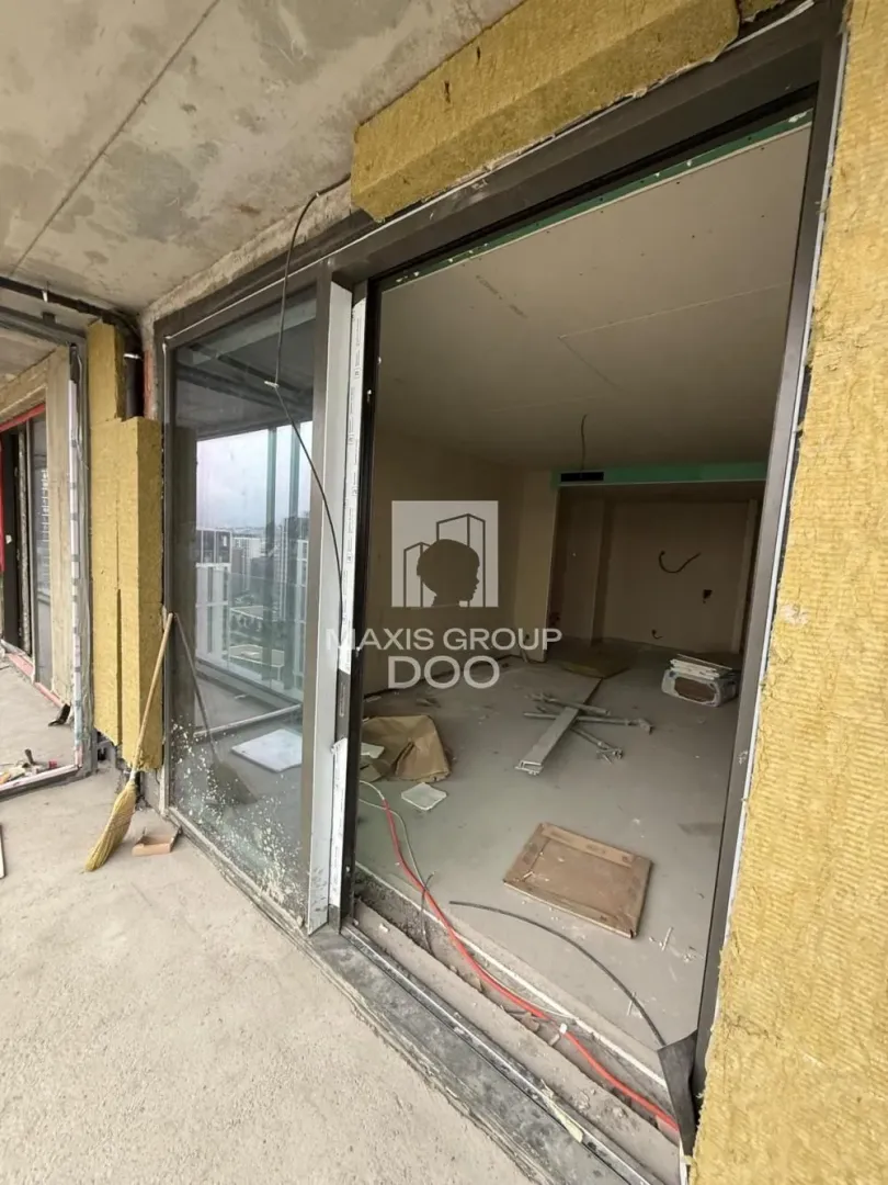 View from an unfinished room towards the balcony and exterior.