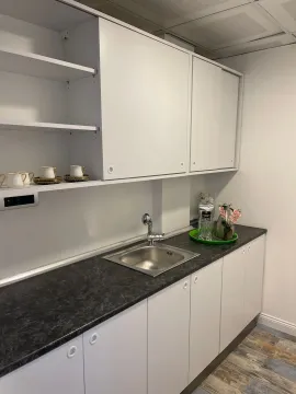 Small white kitchenette with a dark countertop and upper cabinets. - image 19