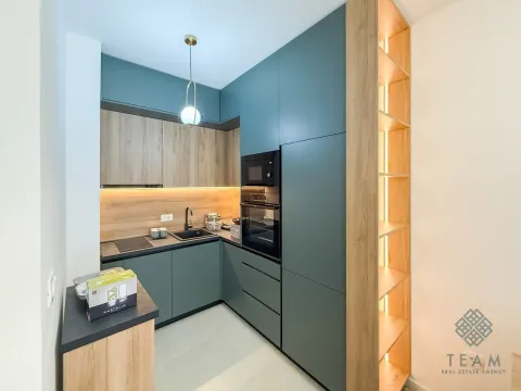 Modern kitchen with dark green cabinets and wooden details. - image 5