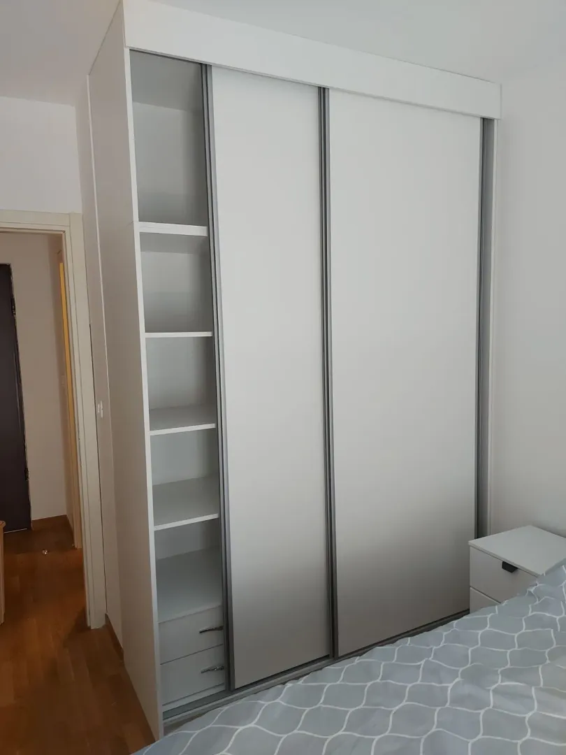 Bijeli ugradni plakar sa kliznim vratima u spavaćoj sobi.