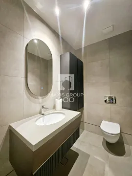 Modern bathroom with a sink, mirror, and toilet. - image 14