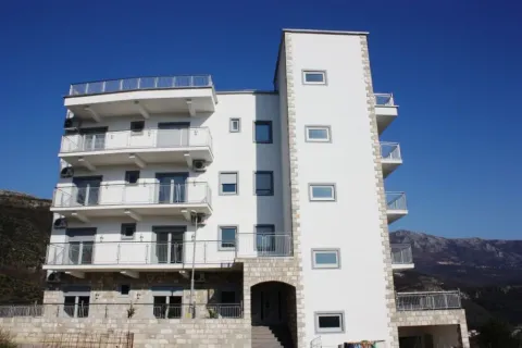 Vanjski izgled moderne stambene zgrade sa bijelom fasadom pod plavim nebom. - image 2