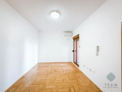 Empty room with parquet flooring, white walls, and an air conditioning unit. - image 6