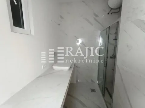 Modern bathroom with marble tiles and a walk-in shower. - image 6