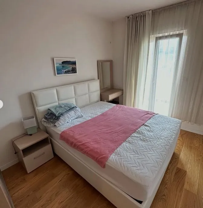 Bedroom with a double bed, bedside table, and balcony access.