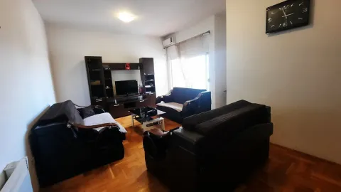 Dnevna soba sa tamnim garniturama za sjedenje i televizorom. - image 3