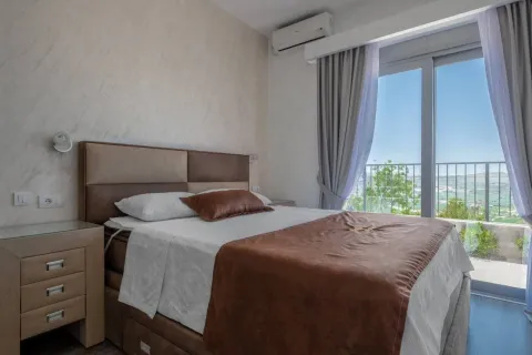 Bedroom with a double bed, bedside table, and access to the terrace. - image 4