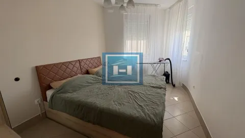 Spavaća soba sa bračnim krevetom i prozorima sa belim zavesama. - image 11