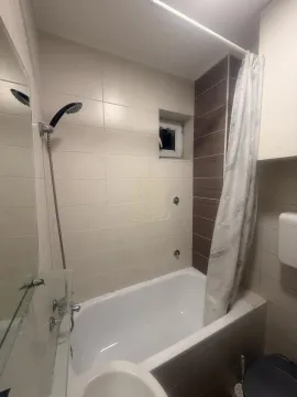 Bathroom with a bathtub, shower, and sanitary ware. - image 8