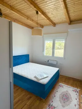 Bright bedroom with a double bed, wooden ceiling, and parquet flooring. - image 5