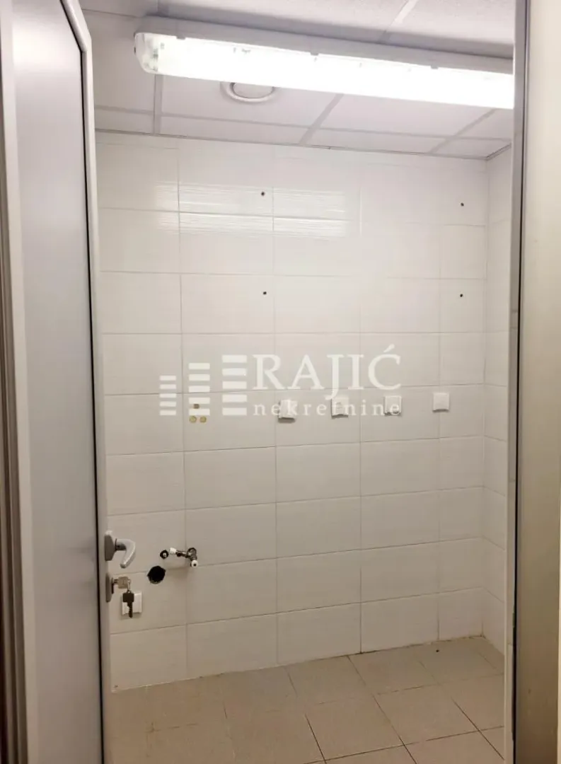 Empty bathroom tiled with white ceramic tiles.