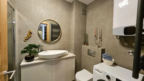 Moderno kupatilo sa lavaboom, ogledalom i veš mašinom. - image 11