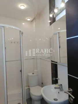 Modern equipped bathroom with a shower cabin, sink, and toilet. - image 10