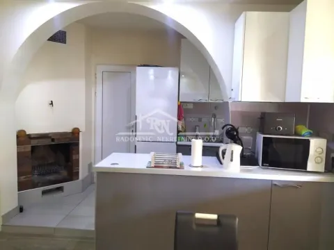 Kitchen with a breakfast bar and a fireplace in the background. - image 7