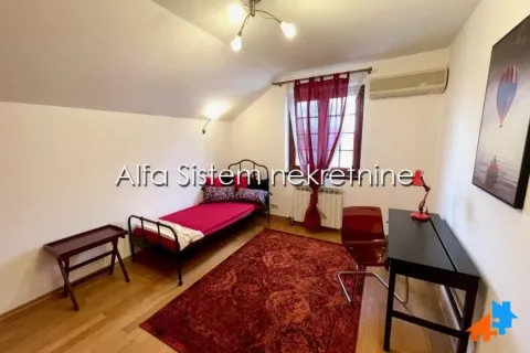 Furnished bedroom with a bed, desk, and rug. - image 16