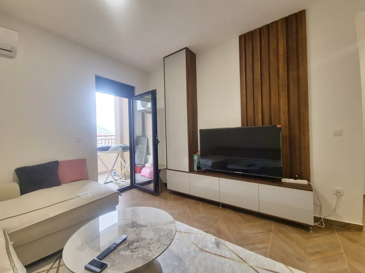Living room with sofa, television and balcony access.