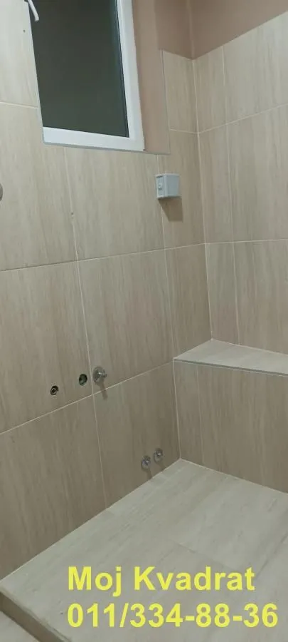 Newly equipped bathroom with ceramic tiles and a walk-in shower.