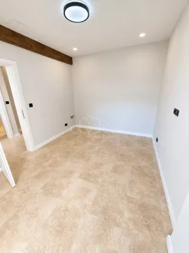 Empty bright room with tiled flooring and a decorative wooden beam. - image 6