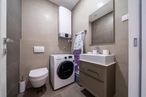 Moderno opremljeno kupatilo sa tuš kabinom, umivaonikom i veš mašinom. - image 9