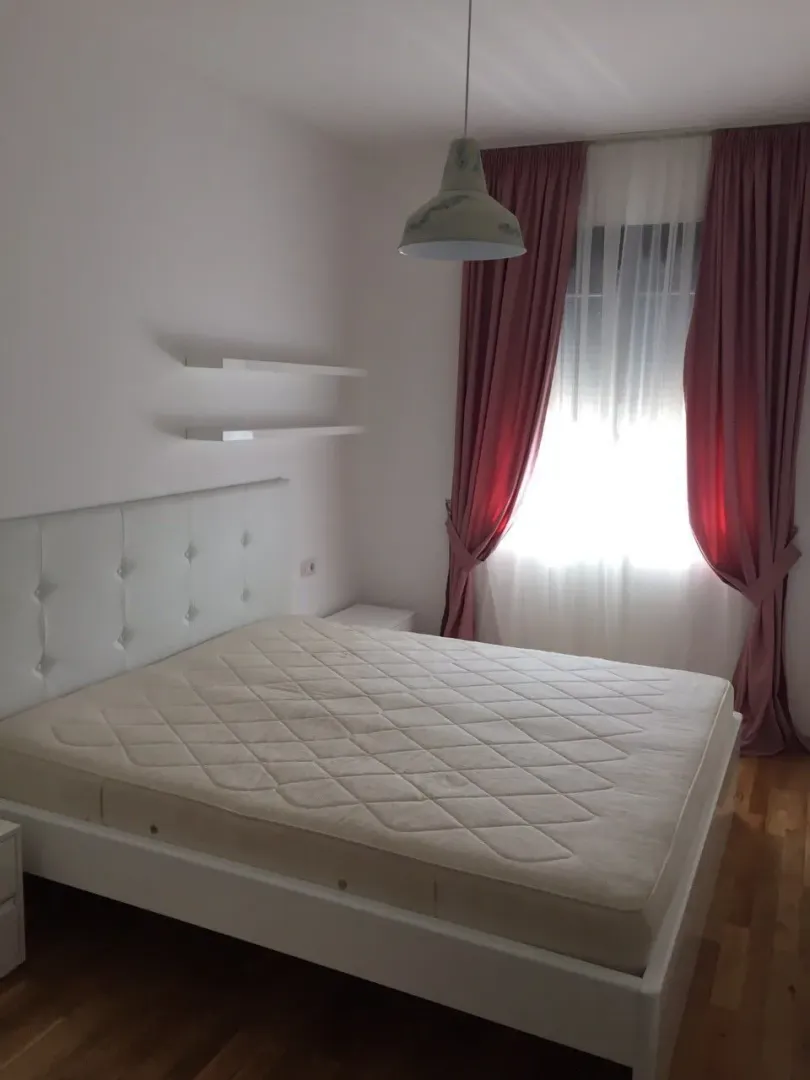 Bright bedroom with a double bed and pink curtains.